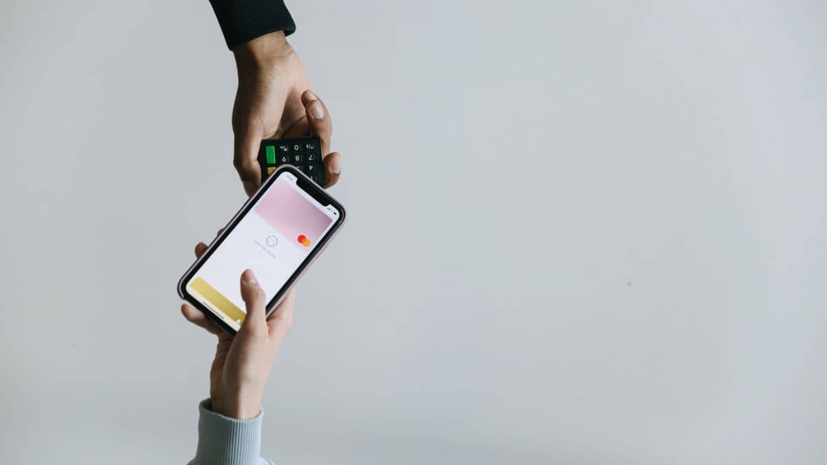 A person paying with a smartphone, representing paying for a domain with M-Pesa