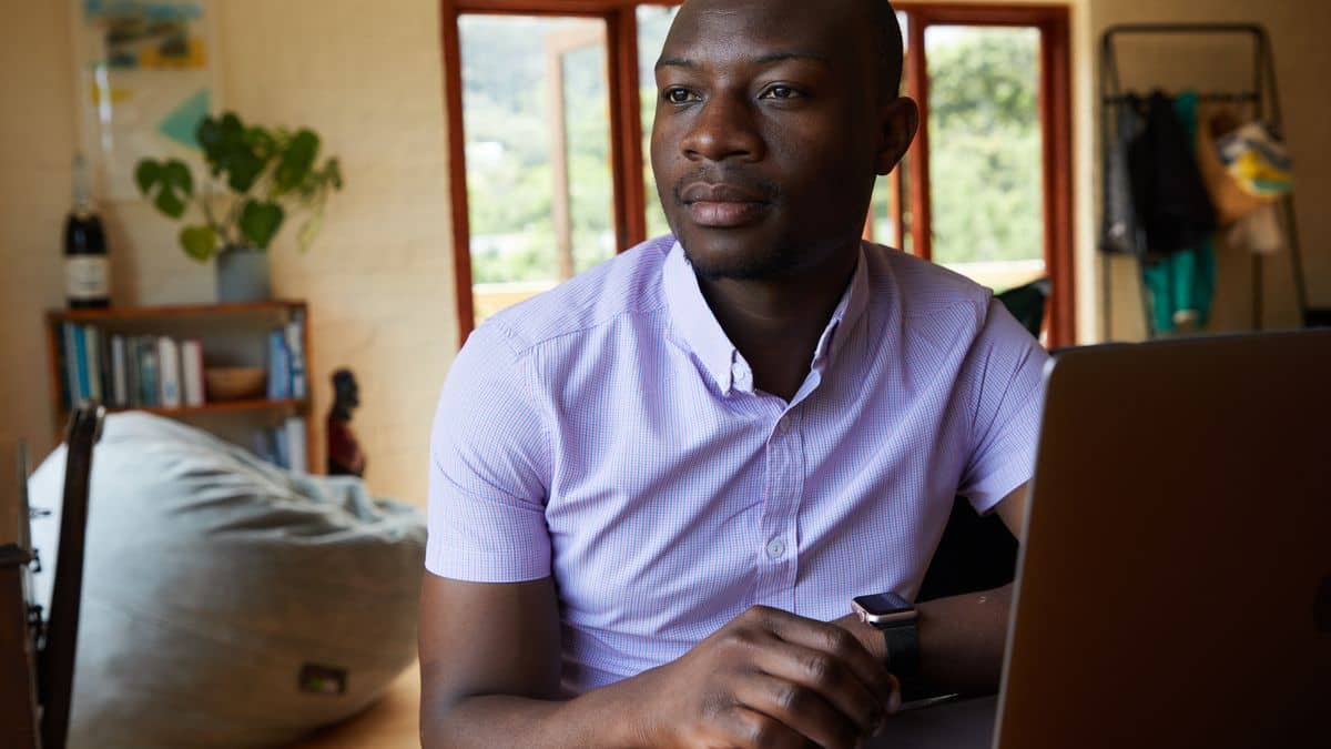 Tanzanian entrepreneur registering a .co.tz domain on a laptop