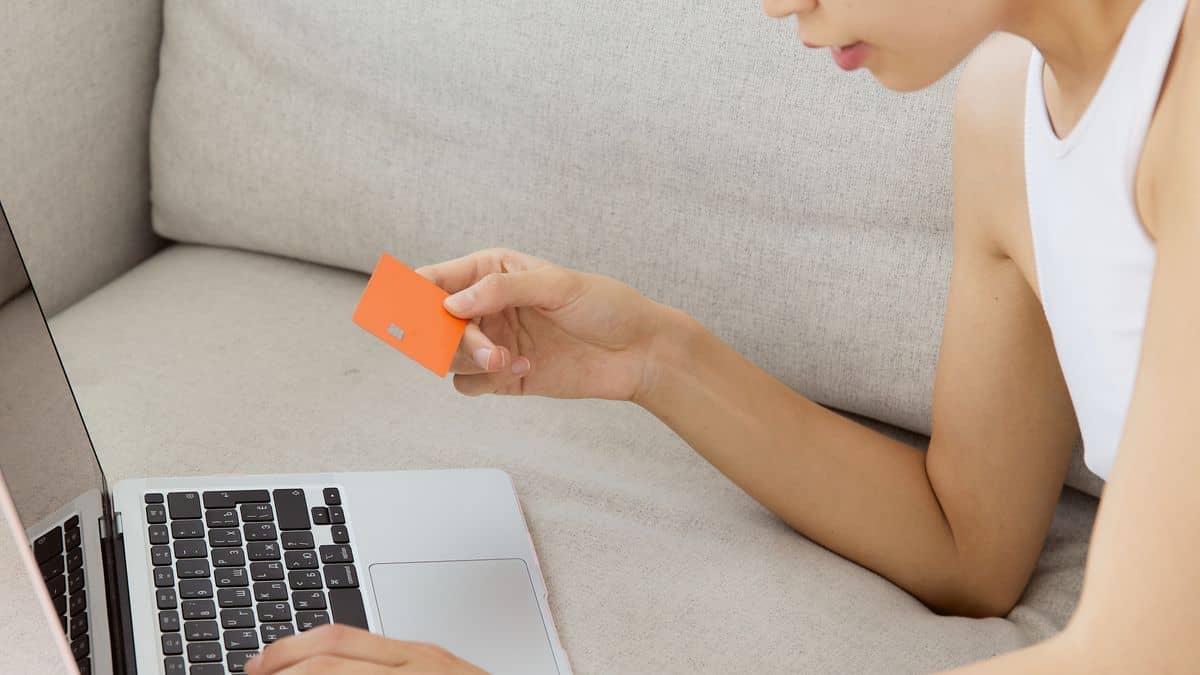Person shopping online with a credit card, representing .shop and .store domains