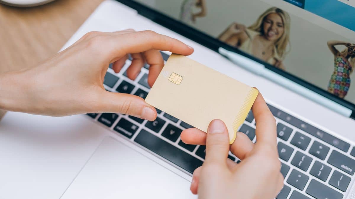 A person with a credit card and laptop budgeting the cost of a website in Tanzania